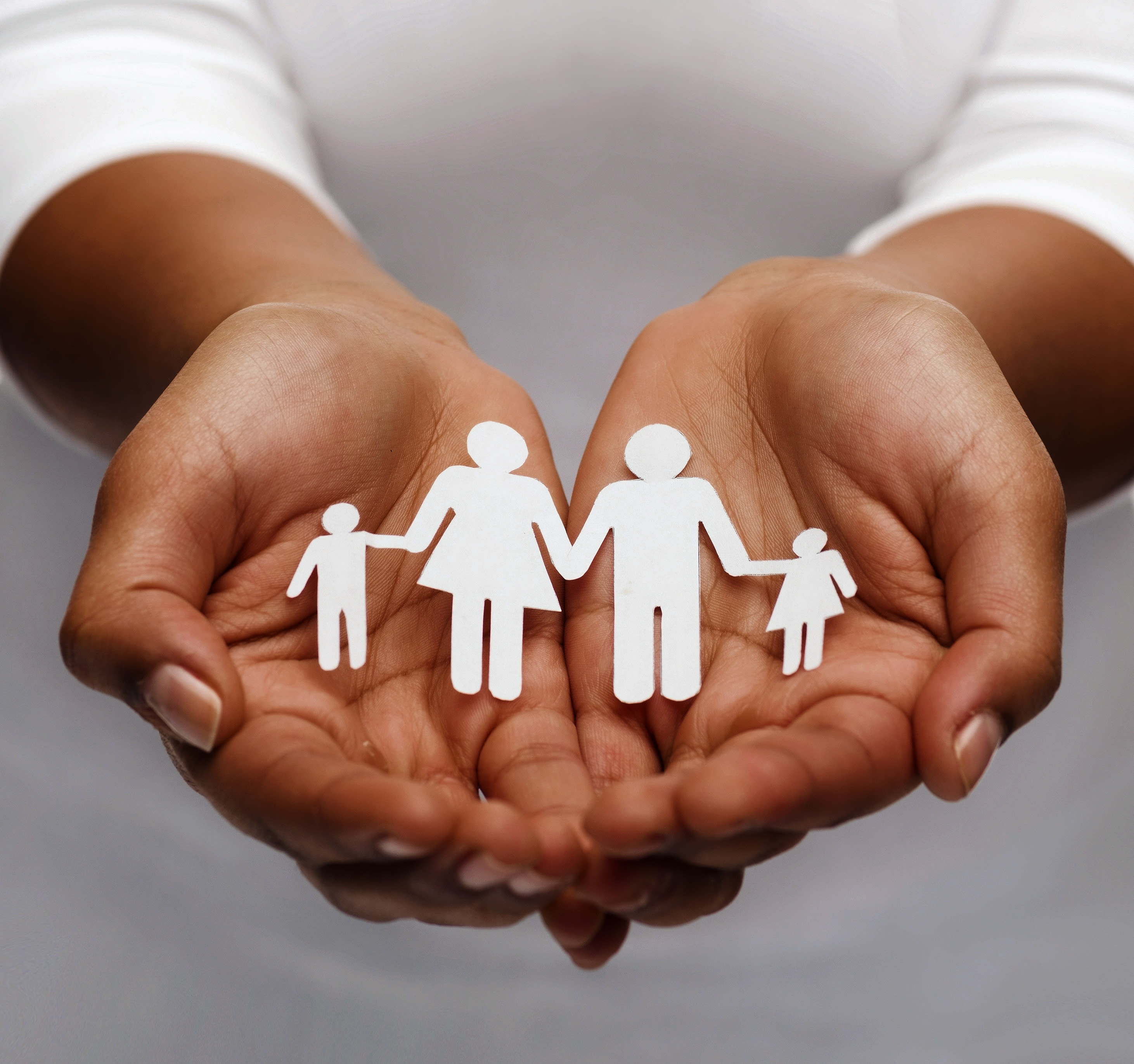Hands holding a paper family